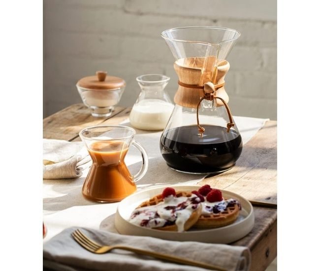 Six-cup glass pour-over coffee maker with an hourglass shape and a wooden collar tied with leather